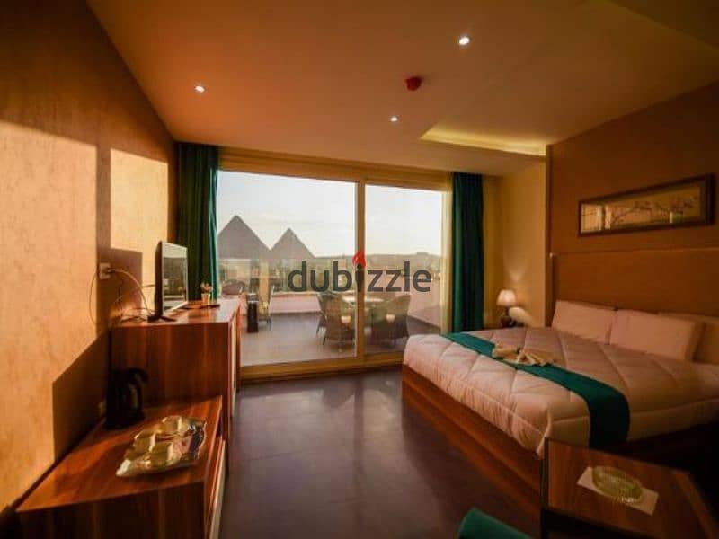 With daily dollar return, a hotel apartment near the pyramids and in front of the Oasis Hotel, two rooms and a reception for sale in a compound, built 1