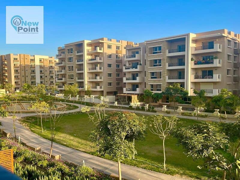 For sale, an apartment with a garden in Taj City, overlooking green spaces, minutes from Nasr City 1