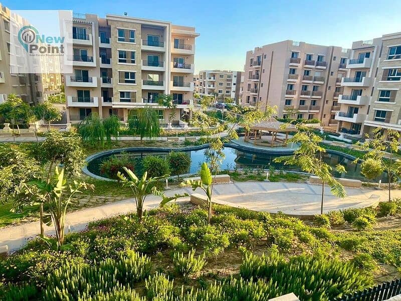 For sale, an apartment with a garden in Taj City, overlooking green spaces, minutes from Nasr City 2