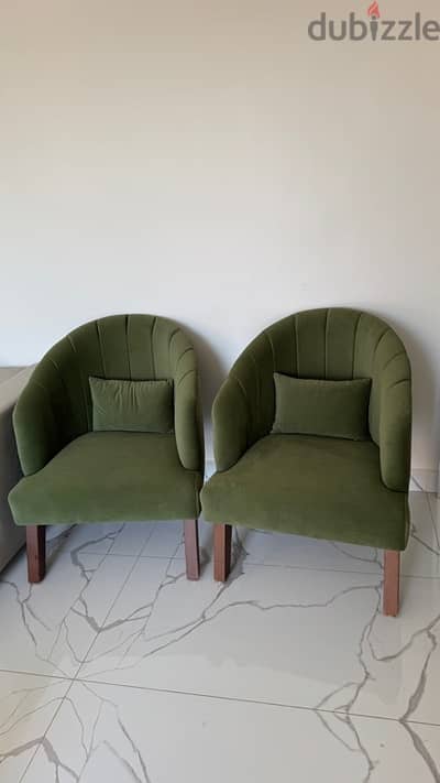 two green chairs with their couches