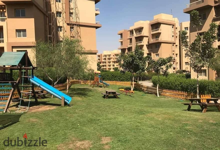 Apartment for sale in October Gardens with easy payment in Ashgar City Compound with a distinctive view of green spaces and trees directly next to the 1