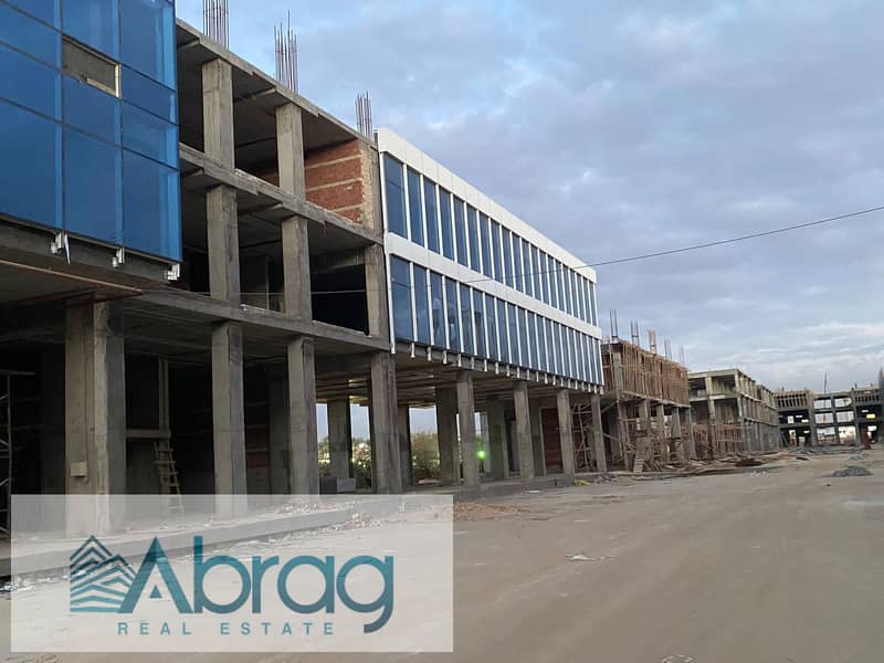 For sale, a commercial store, 125 square meters, immediate delivery, with facilities up to 4 years, West Eleven Mall, in front of Misr University 12