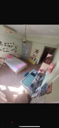 Teenage full bedroom with a pallet of green pink orange and blue 0