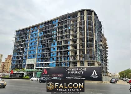 For sale, a fully finished hotel apartment with central AC, next to City Center Almaza Mall, in Marriott Residence, pool view, in installments