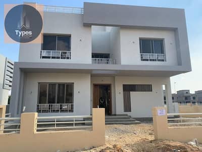 For sale, a detached villa in Grand Heights Compound, immediate delivery, in front of the entrance to Sheikh Zayed 4, with a distinctive view inside