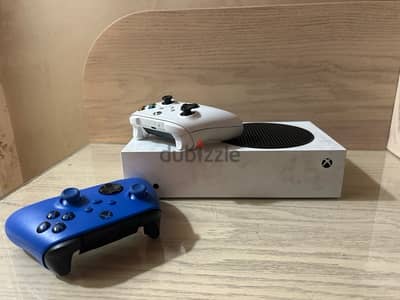 xbox series s with its white controller and an blue controller