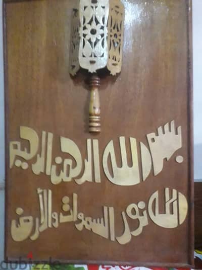 لوحه خشبيه عليها اسم الله والله نور السموات والارض  وبهااضاءه وبها