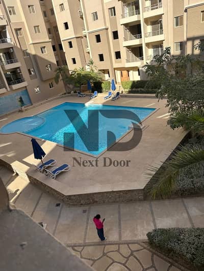 Apartment for sale in La Vida compound with a direct view of the swimming pools and landscaping