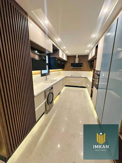Apartment for sale, furnished with air conditioning and kitchen, with a garage space overlooking lagoons, on installment for 7 years in the compound of ALJAR, El Shorouk City