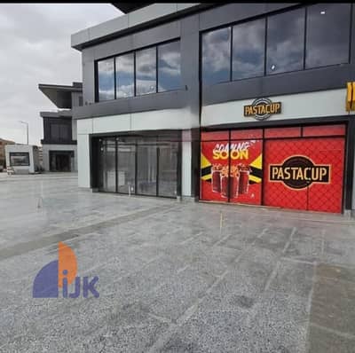 Commercial shop for sale, ready for immediate occupancy, currently rented for 126,000 EGP, with a street-facing storefront and plaza opposite one of t Commercial shop for sale, ready for immediate occupancy, currently rented for 126,000 EGP, with a street-facing storefront and plaza opposite one of t