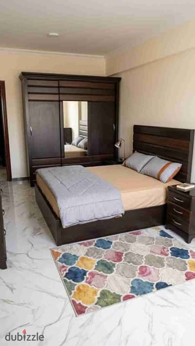 High-end furnished apartment for annual rent, suitable for families, newlyweds, or companies, 3 bedrooms, two-piece reception, kitchen, 2 bathrooms, second upper floor, all facilities available: water, electricity, and natural gas, Alexandria, Al-Ajami, kilo 21, October entrance, very distinguished location.