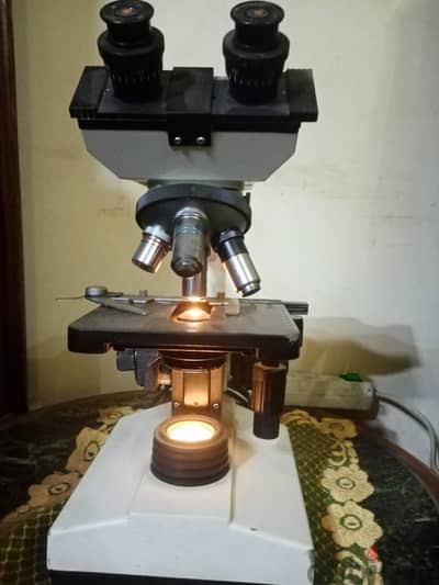 ميكروسكوب  ثنائي بمسرح متحرك و إضاءه  بحاله ممتازه