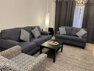 لقطة غرفة معيشة مودرن ٢كنبة وكرسي مع وحدة tvو٣ تربيزه ikea ومكتبه و٢رف