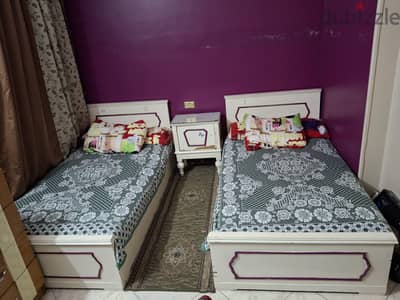غرفه نوم مكونه من سريرين و كومودينو ودولاب