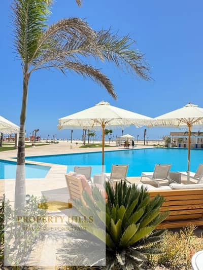 Invest now with ORA Developers at the best price on the North Coast with Naguib Sawiris — a direct lagoon-view chalet, fully finished with air conditi