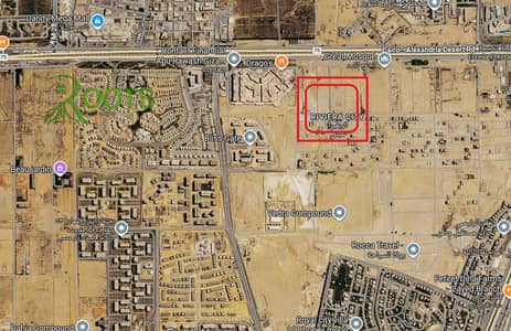 A premium corner plot is available for sale in Green Revolution area, Sheikh Zayed City, directly on the Cairo-Alexandria Desert Road