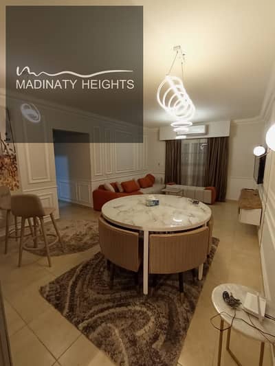 Furnished apartment for rent in Madinaty B12, area 116 square meters, 3 bedrooms, 2 bathrooms, large reception, fully air-conditioned, modern, high-end furniture, complete modern appliances, prime location next to Kraft Zone and East Hub, services ready for immediate occupancy, monthly, for contact 01222956543
