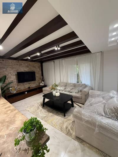 A furnished apartment is available for rent in El Rehab, ground floor with a garden, in front of the old market.