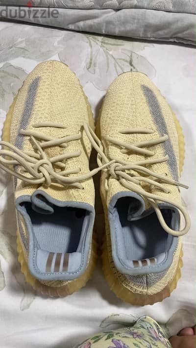 الحذاء هو Adidas Yeezy Boost 350 V2 بلون "Linen".