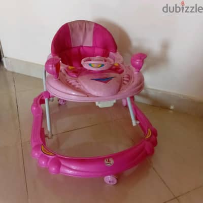 مشاية اطفال مستعملة وبحالة جيدة تصدر موسيقى و لونها pink وقابلة للطى