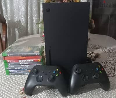 xbox series x with two controllers and a bundle of physical games