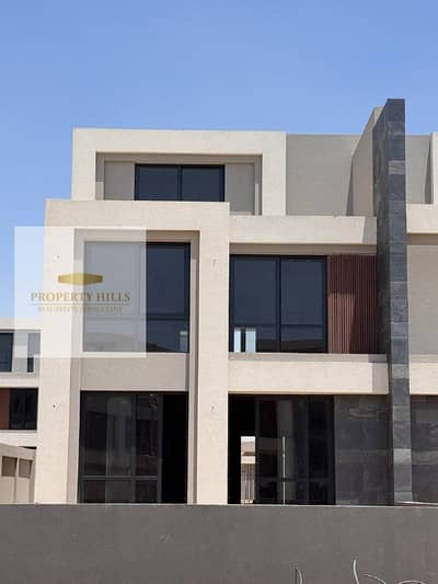 Villa for sale with a large garden area in the patio town with a view of the landscape next to AUC in the Fifth Settlement