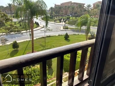 A furnished apartment with a wide garden view and modern kitchen finishes in Al Rehab, close to all services.