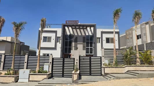 Villa for sale with a garden swimming pool and a private roof | Next to Palm Hills New Giza | 5 bedrooms | 5 bathrooms | 540 m land 300 m buildings Al-Khamail compound Sheikh Zayed Al-Khamail location Mem