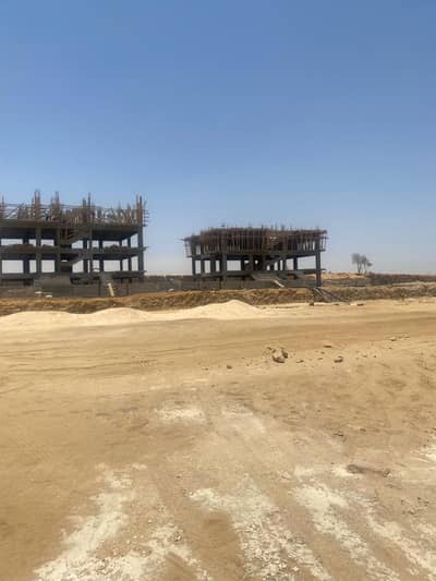 Luxury villa plot for sale in the Green Belt area of ​​Sheikh Zayed, located within a gated community opposite Al Ahly Club; features a prime location
