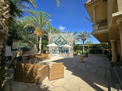 Two twin villas for sale in Madinaty, overlooking a large, open garden.