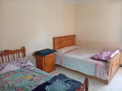 Furnished apartment for annual rent for a family, a groom, a student, or a company, 2 bedrooms, two-piece reception, kitchen, bathroom, fourth floor, superior, all facilities available: water, electricity, natural gas, and elevator in Alexandria, Al-Ajami, kilo 21, main October street, before the gate, in a very distinguished location.