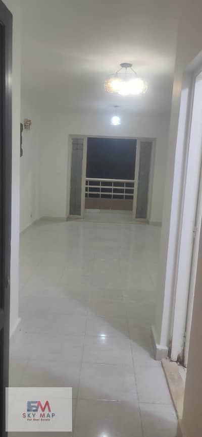 For rent in Madinaty (New Law): Ground-floor apartment with a garden in B6. It features an area of ​​124 sqm plus a 50 sqm garden. The unit boasts a p