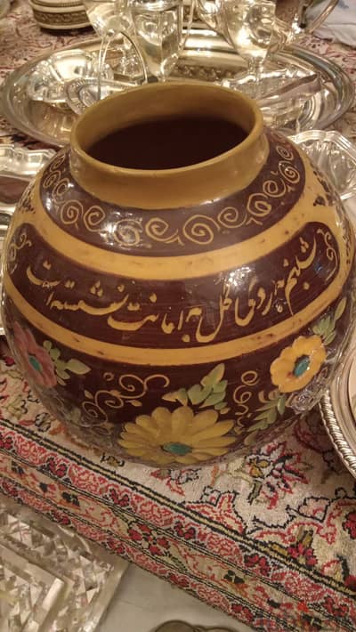 ​This vessel features traditional slip-trailed calligraphy and floral