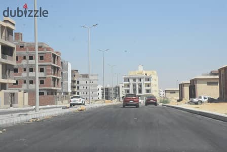 Land for sale: Corner plot facing a walkway, second row from the main road, just steps away from Palm Hills in the Beit Al-Watan district, Fifth Settl