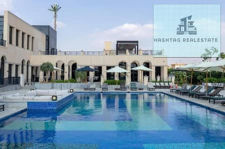 Duplex for sale in Compound One Hyde Park, Fifth Settlement with modern design, lagoon view, and iconic towers