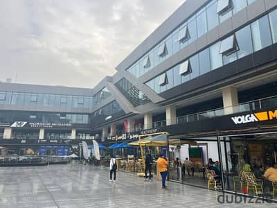 For rent in The Gate Plaza Mall, in the heart of Sheikh Zayed City: a 122-square-meter shop with a 58-square-meter outdoor area.