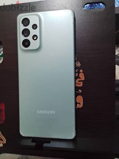 هاتف Galaxy A73 بحاله كويسة مع بعض الخدشات في الظهر والصدمات