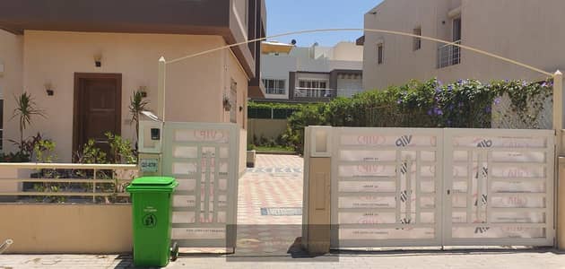 A distinctive 367m² finished twin house with a garden is available for rent in the Grand Heights compound. It is located on the Boulevard Axis, close