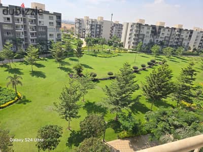 For rent in Madinaty (B12): 200 sqm unit with a garden view. Features 3 bedrooms, 3 bathrooms, and a living area that can serve as a fourth bedroom.