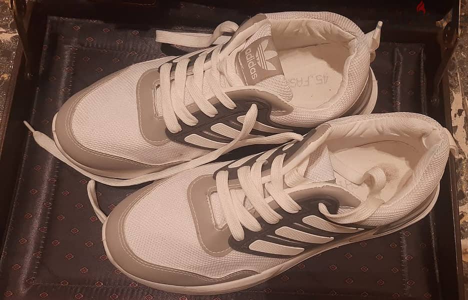 حذاء ماركة ( Adidas ) مقاس 45 . جديد لانج لم يستخدم . أبيض في رمادي 1