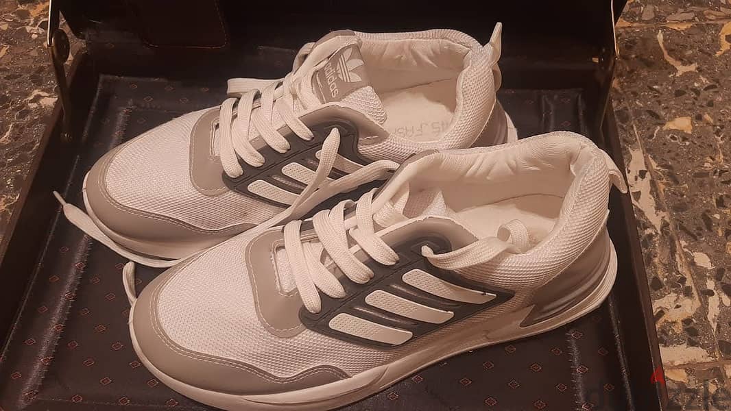 حذاء ماركة ( Adidas ) مقاس 45 . جديد لانج لم يستخدم . أبيض في رمادي 2